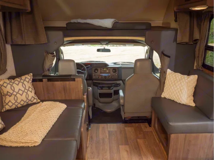 Comfortable RV rental interior, showing a versatile living space with a dinette, overhead bunk, and front cabin.. Winnebago Minnie Winnie 2020