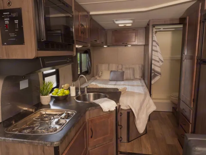 This RV rental offers a compact kitchen with a stove, sink, and microwave, a comfortable bed, and a functional wet bath.. Winnebago Minnie Winnie 2020