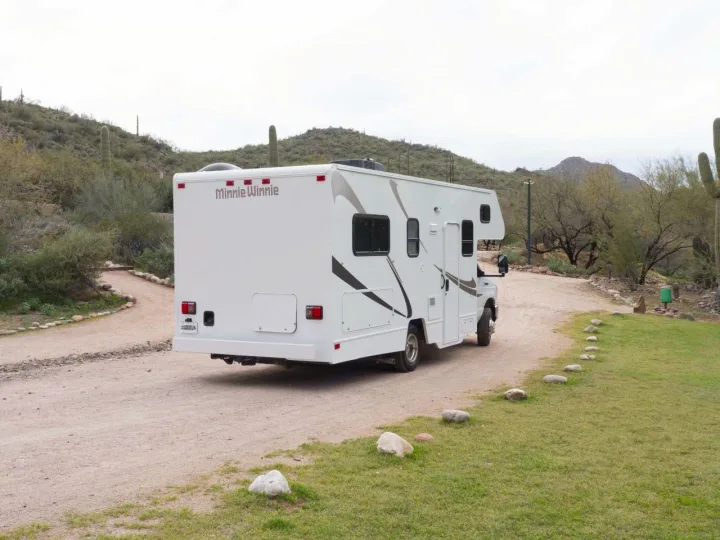 Minnie Winnie rv rental parked on a desert dirt road with saguaro cacti, perfect for adventure travel.. Winnebago Minnie Winnie 2020