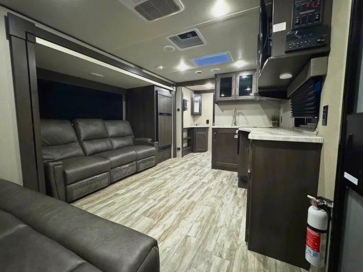 Explore this spacious, modern RV rental interior featuring a comfortable living area, full kitchen, and stylish finishes.. Grand Design Transcend Xplor 2022