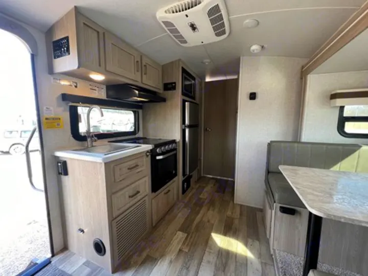 Inside an RV rental: Compact travel trailer with a functional kitchen, dining area, and wood flooring.. Rockwood GeoPro 2022