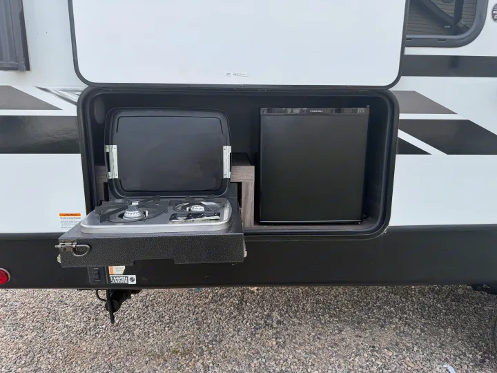 This RV rental features a convenient outdoor kitchen with a two-burner stove, griddle, and refrigerator.. Dutchmen Kodiak Ultra Lite 2021