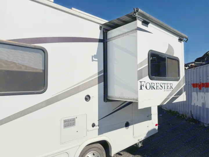 This RV rental has an extended slide-out, white exterior, windows, and utility access. Note the worn side graphics.. Forester LE 2016