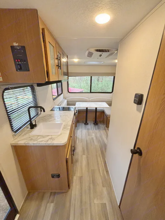 This RV rental offers a modern interior with a well-equipped kitchen, comfortable dinette, and large windows.. Avenger 16RD 2024