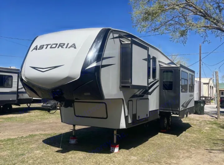 Astoria fifth-wheel RV rental, grey and black, with slide-outs extended, parked in a campsite.. Dutchmen Astoria 2018