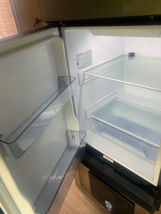 This clean, empty Furrion refrigerator, with clear shelves and door bins, is ready for your RV rental adventure.. Jayco Jay Flight 2023