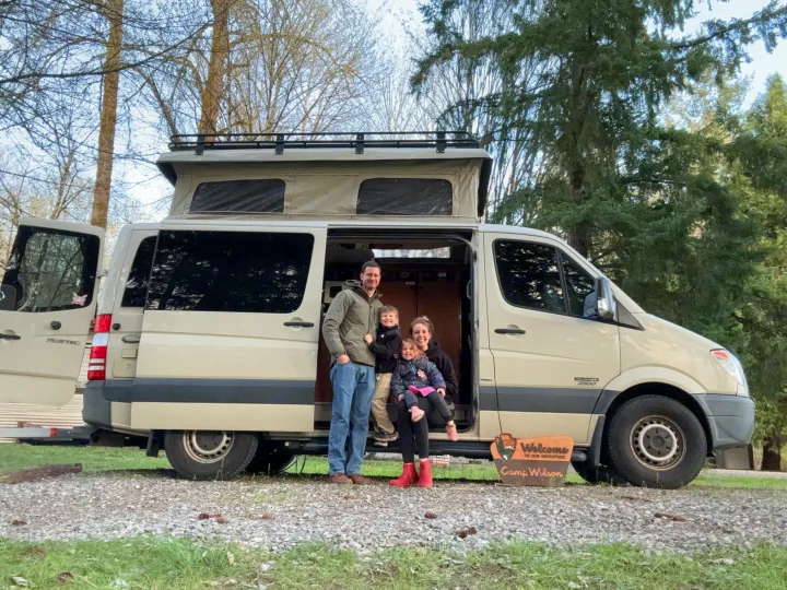 Happy family with their pop-top RV rental, a tan camper van, ready for adventures.. Sportsmobile Regular Body 2013