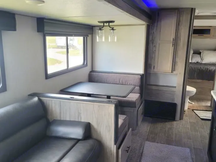 Modern RV rental interior showcasing a spacious dinette, comfortable sofa, and inviting living area. Ideal for travel.. Forest River Cherokee Alpha Wolf 2021