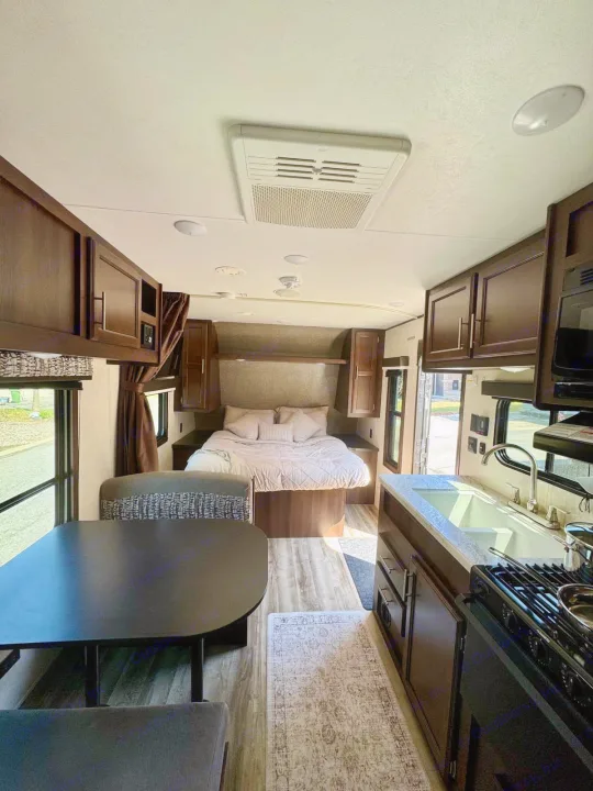 Cozy RV rental interior showcasing a bedroom, dining area, and full kitchen. Ideal for travel adventures.. Jayco Jay Flight SLX 2019