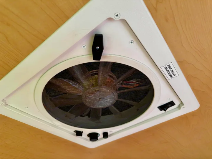RV rental's ceiling-mounted Fantastic Vent fan with a mesh screen and a "Please Ventilate Cabin for Sleeping" sticker.. Pleasant Valley/NuCamp T@B 2016