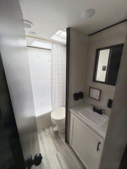 Bright RV rental bathroom featuring a tub/shower, toilet, and vanity with sink. Practical amenities for your travels.. Jay Flight SLC 260BHW 2025