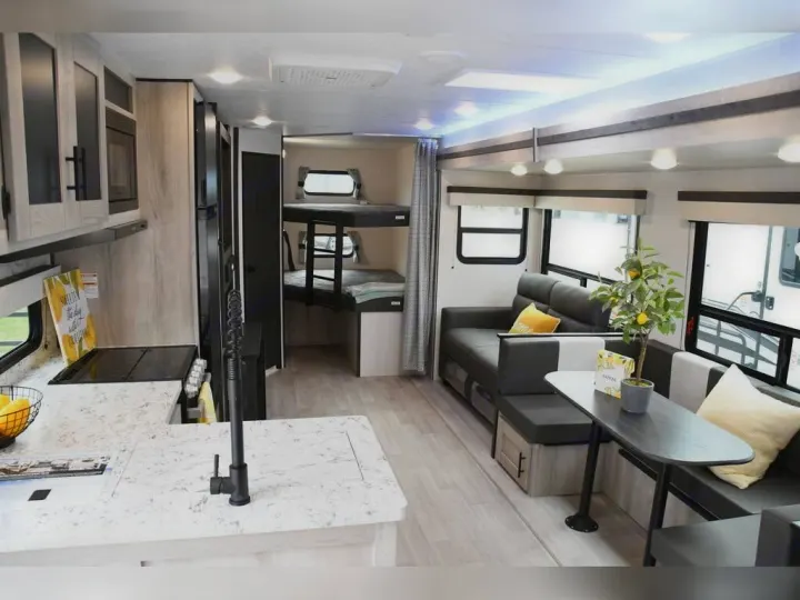 This rv rental offers a modern interior, featuring a well-equipped kitchen, bunk beds, and a comfortable living/dining area.. KZ Connect C291BHK 2023