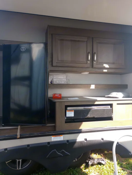 This RV rental features a convenient outdoor kitchen: a mini-fridge, storage cabinets, and a built-in grill.. Keystone RV Cougar 2022