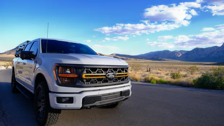 Explore scenic desert trails with this rugged Ford F-150 Tremor pickup, ideal for adventure rv rental. Mountains in background.. Ford Roofnest 2024