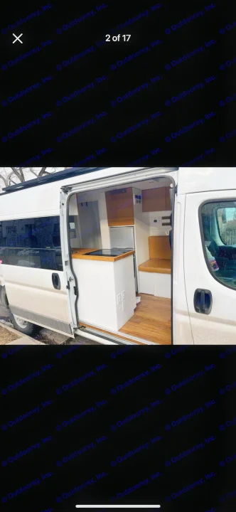 RV rental: Modern camper van interior, featuring a compact kitchen with wood counter, mini-fridge, and a cozy bench seat.. Custom Ram Promaster 2021
