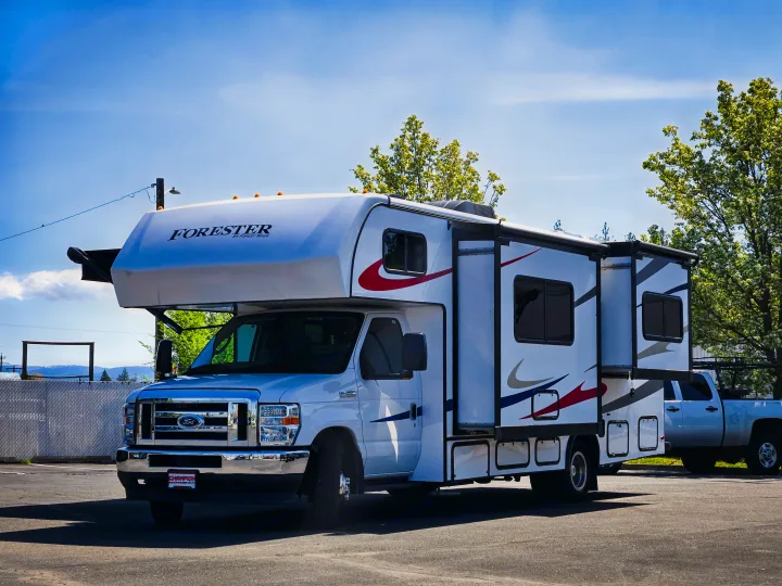 White Forester RV rental with extended slide-outs, parked in a sunny lot, ideal for camping and road trip adventures.. Forester Classic 2022