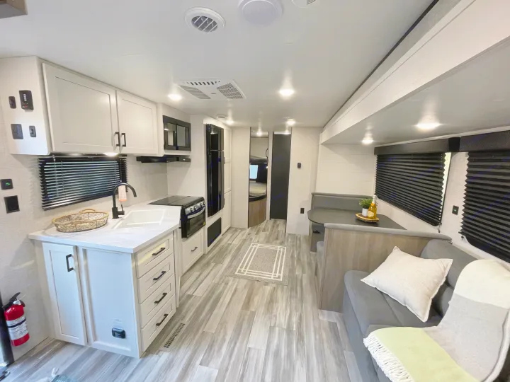 Spacious RV rental interior with modern white kitchen. Jayco 261BHSW 2025