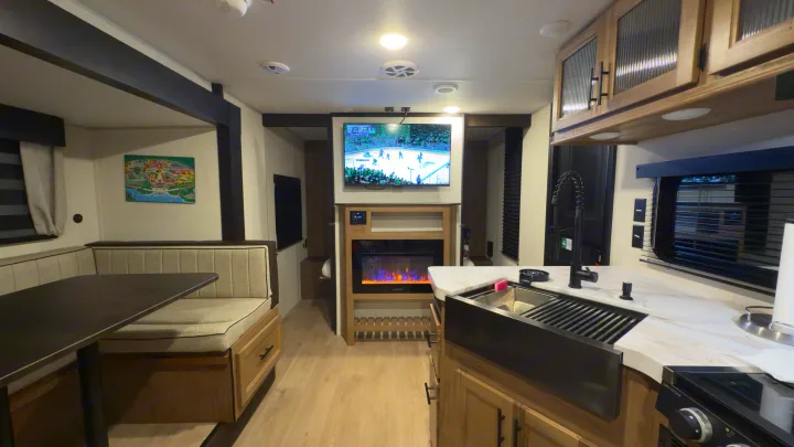 Spacious RV rental interior, showcasing a modern kitchen, dinette, and fireplace. Perfect for your next trip.. Forest River Grey Wolf 23DBH 2025