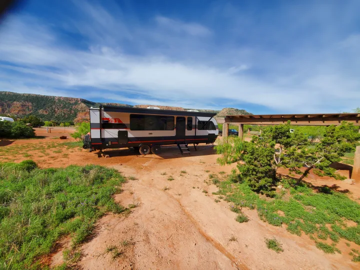 Forest River RV rental travel trailer parked at a scenic red-dirt campsite surrounded by desert mesas.. Forest River Salem Platinum 2024