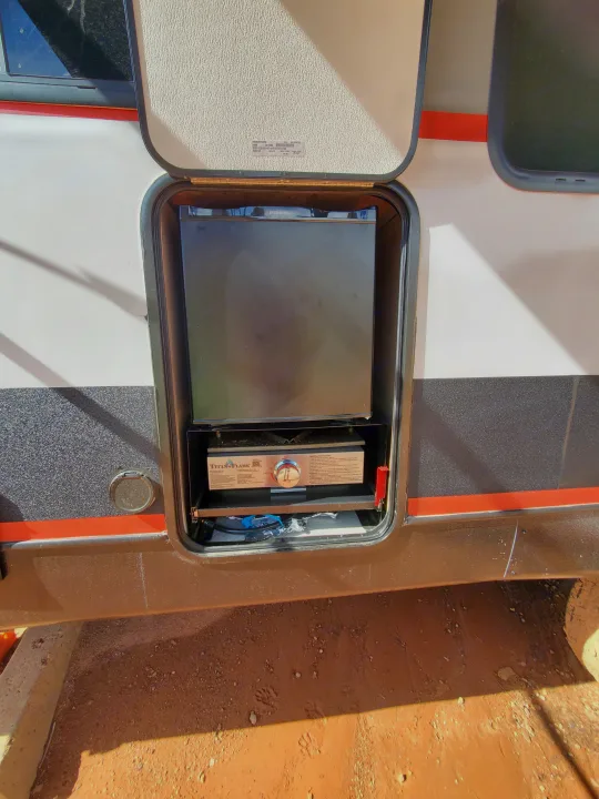 Open RV rental compartment with Everchill fridge and Titan Flame outdoor stove for convenient camp cooking.. Forest River Salem Platinum 2024
