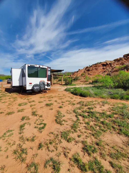 RV rental parked at a scenic red rock campsite under a beautiful blue sky. Ideal for your next outdoor adventure.. Forest River Salem Platinum 2024