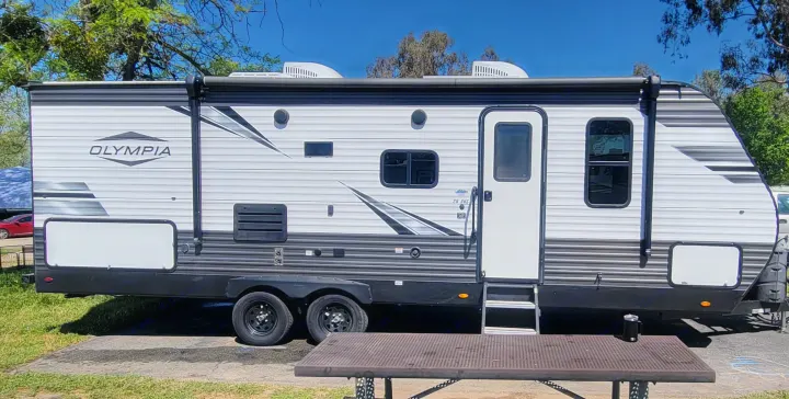 Spacious Olympia travel trailer, perfect for your next RV rental adventure, parked under clear skies at a campsite.. Highland Ridge RV Olympia 2022