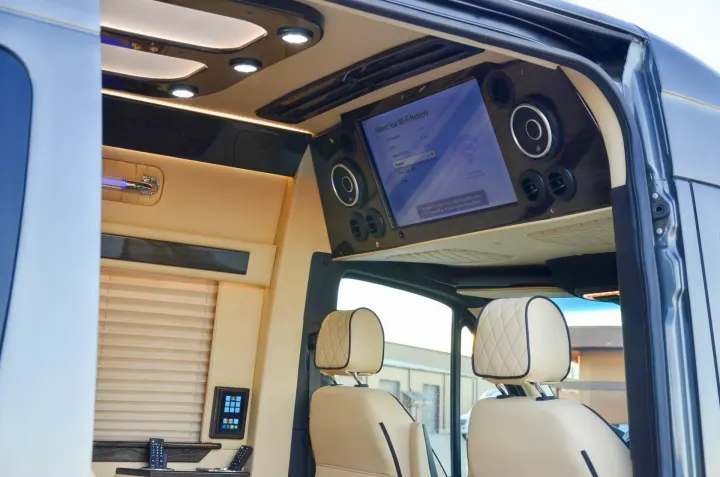 Experience an RV rental with luxury: Smart interior featuring a large screen for Wi-Fi, custom lighting, and plush seating.. Ultimate Toys Ultimate Commuter 144 2022