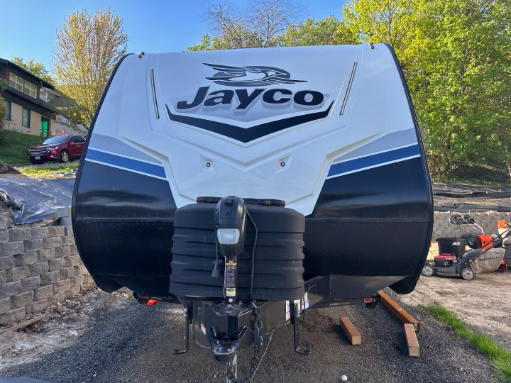 Jayco RV rental: Front view of white, black, and blue travel trailer with Jayco logo and hitch.. Jayco Jay Feather 2024