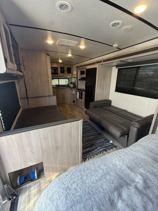 Explore this RV rental's inviting interior: functional kitchen, lounge with pull-out sofa, and comfortable sleeping space.. Forest River Coachmen Northern Spirit Ultra Lite 2023