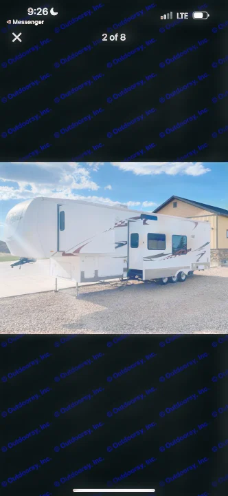 This white fifth-wheel RV rental is parked on a gravel lot. Its slide-outs are extended, showcasing its spacious design.. Heartland RVs Cyclone Toy Hauler 2008