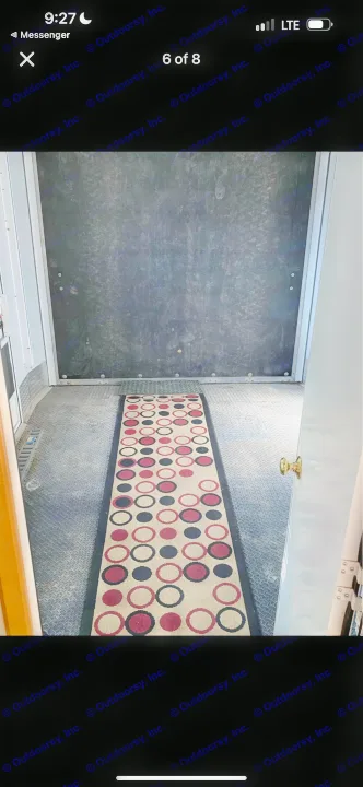 RV rental interior showing a diamond plate floor, dark wall panels, and a long runner rug with circular patterns.. Heartland RVs Cyclone Toy Hauler 2008