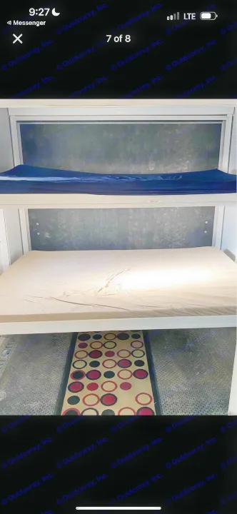 RV rental bunk beds (300 lb capacity) with blue and tan mattresses, above a patterned rug on diamond plate flooring.. Heartland RVs Cyclone Toy Hauler 2008