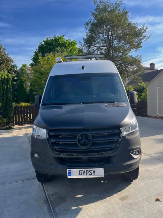 Sleek black & white Mercedes-Benz Sprinter adventure van, ideal for rv rental. Parked on a sunny driveway, ready for journeys.. Thor Tranquility 2023