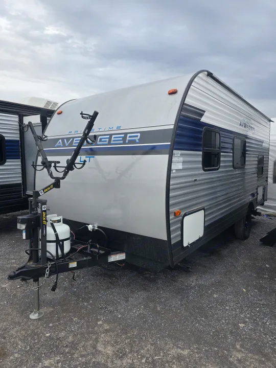 A Primetime Avenger LT travel trailer with a front bike rack and propane tanks, perfect for your next RV rental trip.. Prime Time Avenger LT 16BH 2023