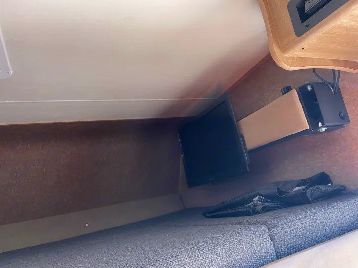 Inside an RV rental: a compact sleeping area with a small TV mounted above a grey cushioned bed.. Forest River Coachmen Freelander 2015