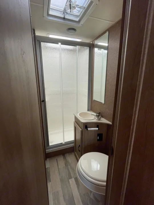 Compact RV rental bathroom with shower, sink, and toilet. Perfect for your road trip comfort.. Forest River Coachmen Freelander 2015