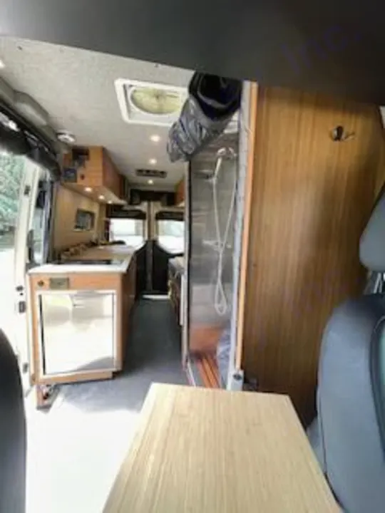 Interior of a spacious camper van available for RV rental, featuring kitchen, fridge, and shower.. Mercedes-Benz Sprinter RV Motorhome Campervan 2020