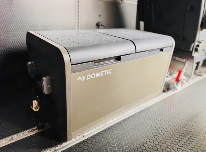 Dometic portable refrigerator in an RV rental. Keeps your food cool on adventures. Features a textured floor.. Mercedes-Benz Sprinter 2022