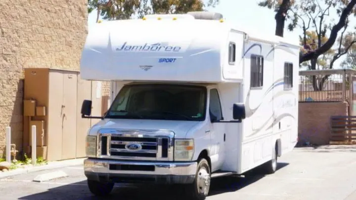 A white Jamboree Sport Class C RV, built on a Ford chassis, is parked in a lot. A common choice for RV rental.. Jamboree Sport 2010
