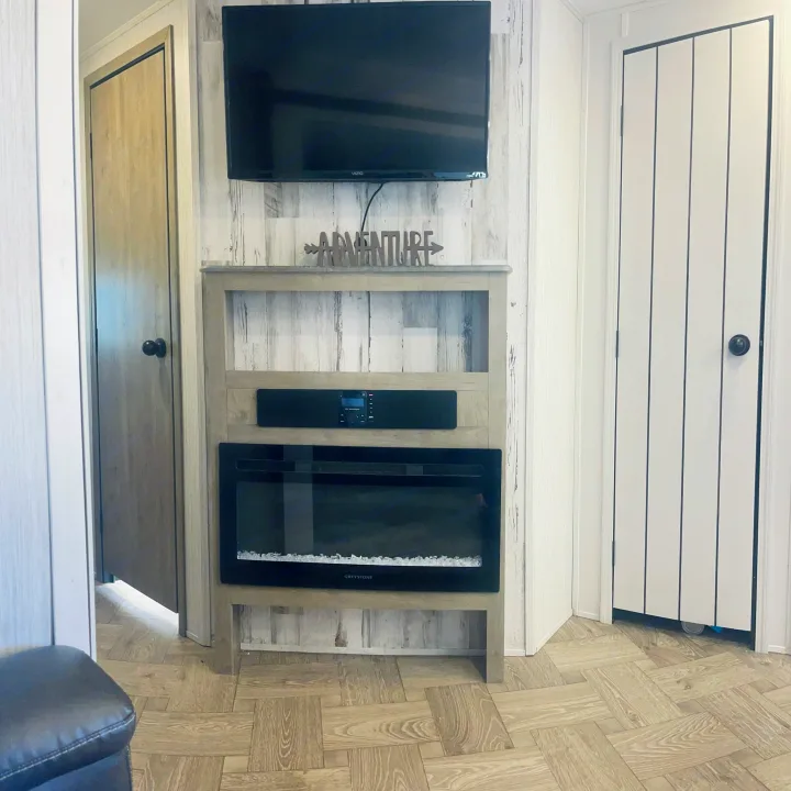 RV rental: Modern living space with TV, electric fireplace, shiplap walls, and wood-look flooring.. Forest River Palomino Puma 2022