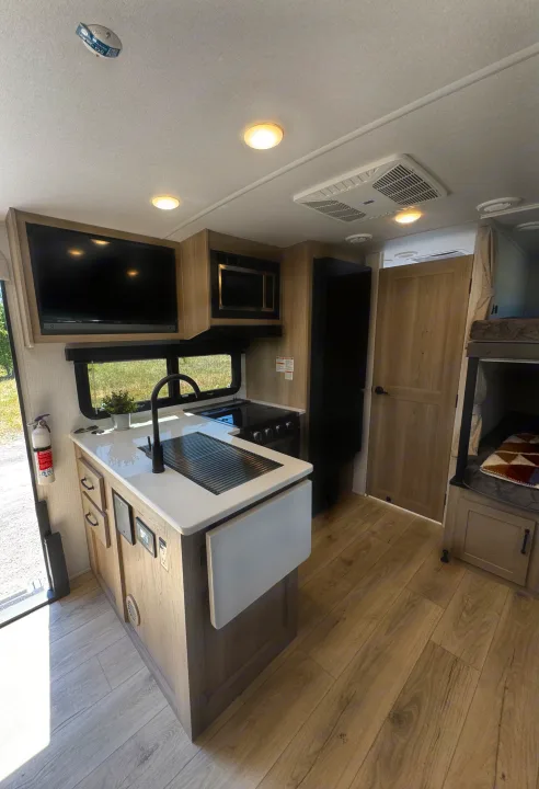 Step inside this modern RV rental! View of the light-filled kitchen, living area with TV, refrigerator, and bunk beds.. Flagstaff Micro Lite 25DBH 2025