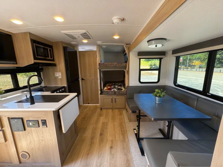 Spacious & modern RV rental interior with a full kitchen, dining area, and bunk beds, ideal for family adventures.. Flagstaff Micro Lite 25DBH 2025