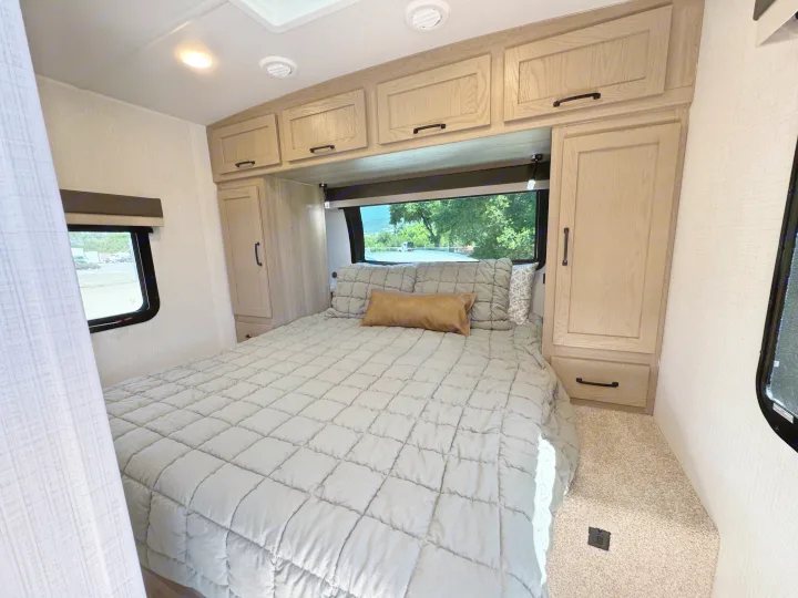 Cozy RV rental bedroom features a comfy bed, overhead storage, and scenic window views.. Flagstaff Micro Lite 25DBH 2025