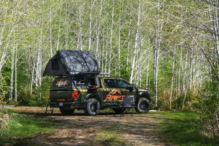 Explore with this Ford Raptor overlanding RV rental, complete with rooftop tent, parked in a scenic forest. Ready for adventure!. Ford Ford F150 2024