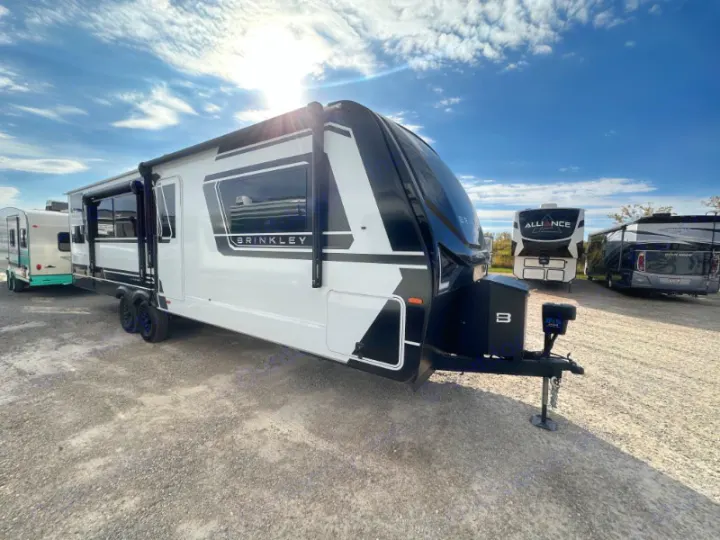 Modern white & black Brinkley travel trailer (RV) on gravel lot. Ideal rv rental for your next outdoor adventure.. Brinkley Air 295 2025