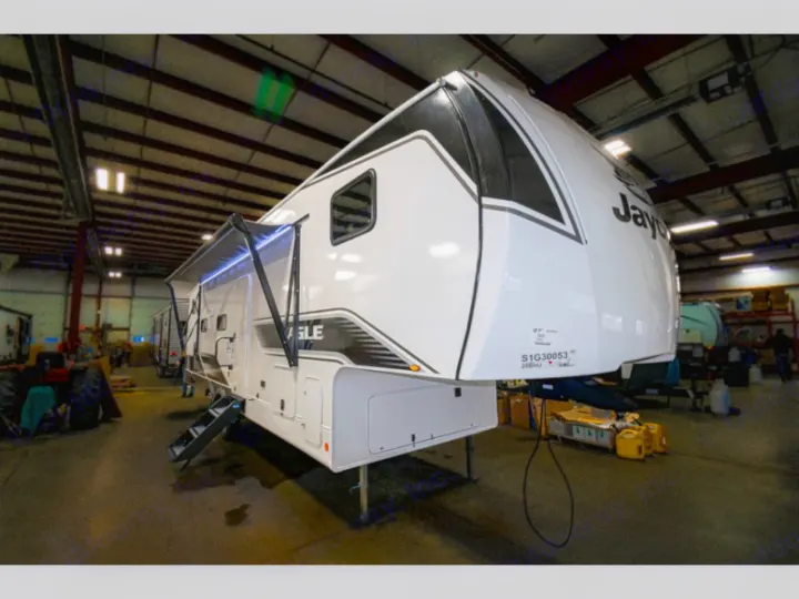 White Jayco Eagle fifth-wheel RV, with awning & steps, inside a factory. Great for your next rv rental trip.. Jayco Eagle Super Lite 2025