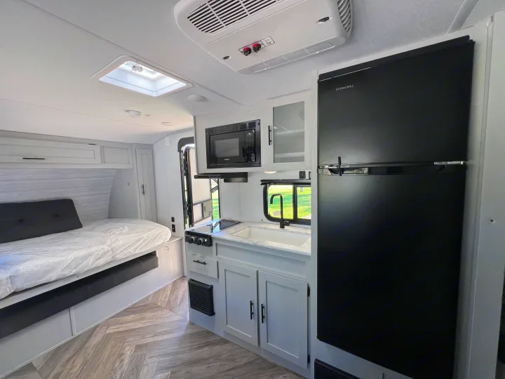 Spacious RV rental interior featuring a modern kitchen, comfortable bed, and large fridge.. Forest River Salem FSX 2021