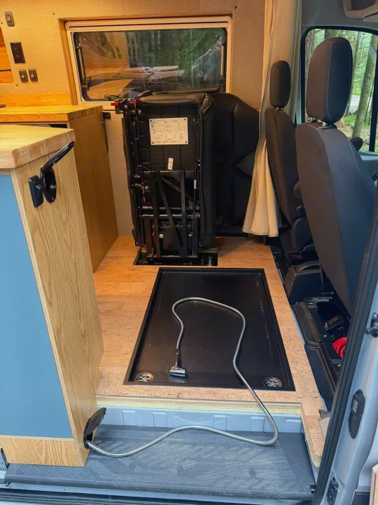 RV rental: Versatile camper van interior featuring foldable seating, a kitchenette, and an integrated indoor/outdoor shower.. Ford Transit 2023
