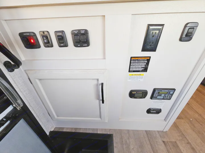 RV rental interior: control panel with main power, awning, light, step, speaker switches, solar, and electronic leveling systems.. Jayco Greyhawk 2023