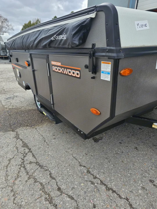 Rockwood pop-up camper side view, ideal for rv rental. Features warning labels & durable design for travel.. Forest River Rockwood LTD 2024